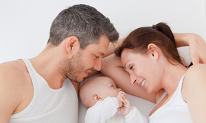 Frau, Mann und Baby im Bett