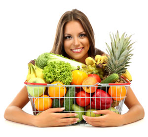 Frau mit viel Obst und Gemüse